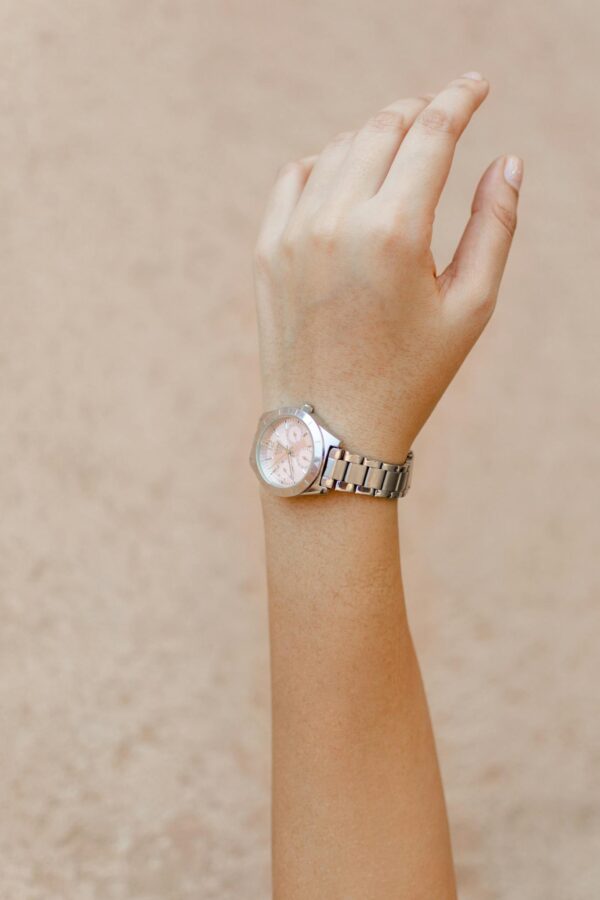 Close-up shot of a woman's hand wearing an elegant wristwatch, showcasing minimalist design and style.
